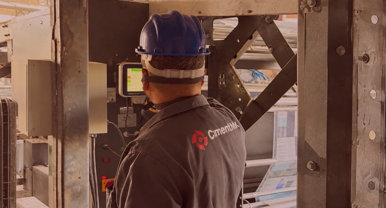 Funcionário Cimentmix com capacete operando equipamento na fábrica